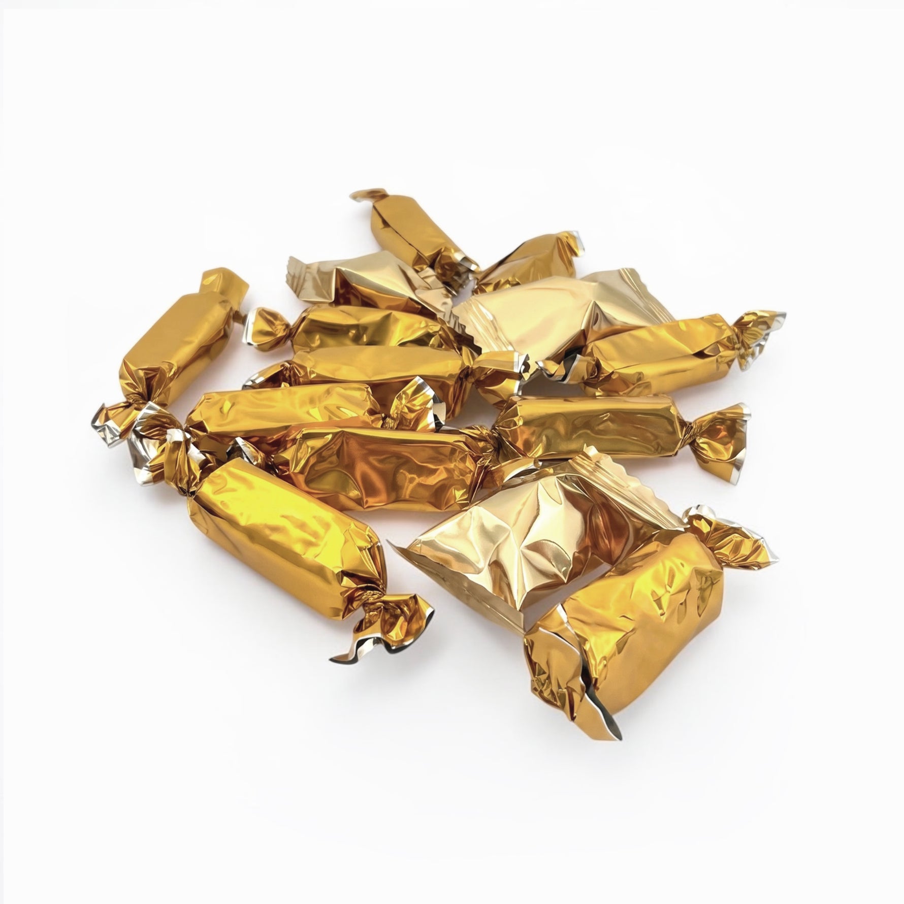 A pile of wrapped candies or chocolates individually wrapped in shiny metallic gold foil, arranged on a plain white background.