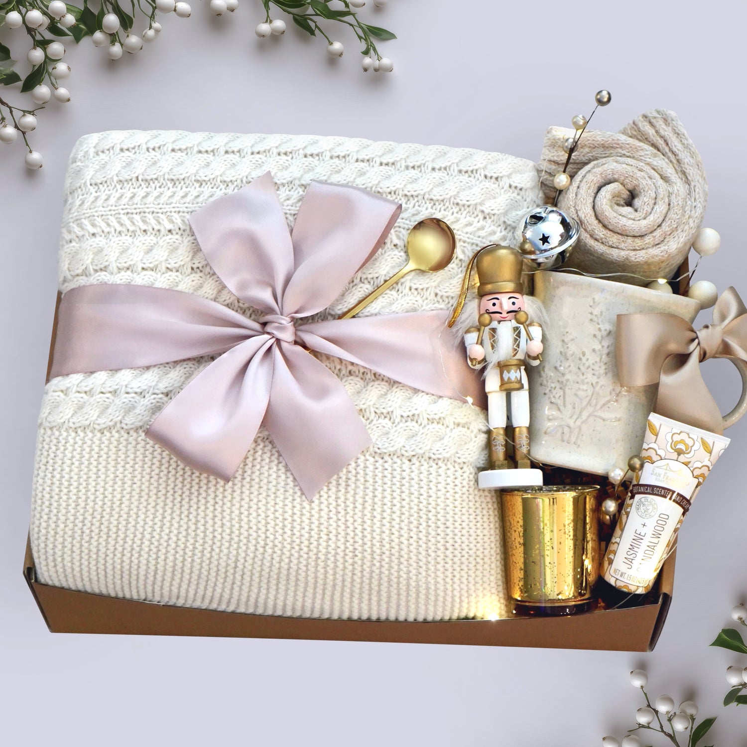 Wildflower Pop Holiday Ballet Blanket box with cream cable knit blanket, nutcracker ornament, lavender ceramic mug, hand cream gold votive and cozy boot socks on grey holiday background