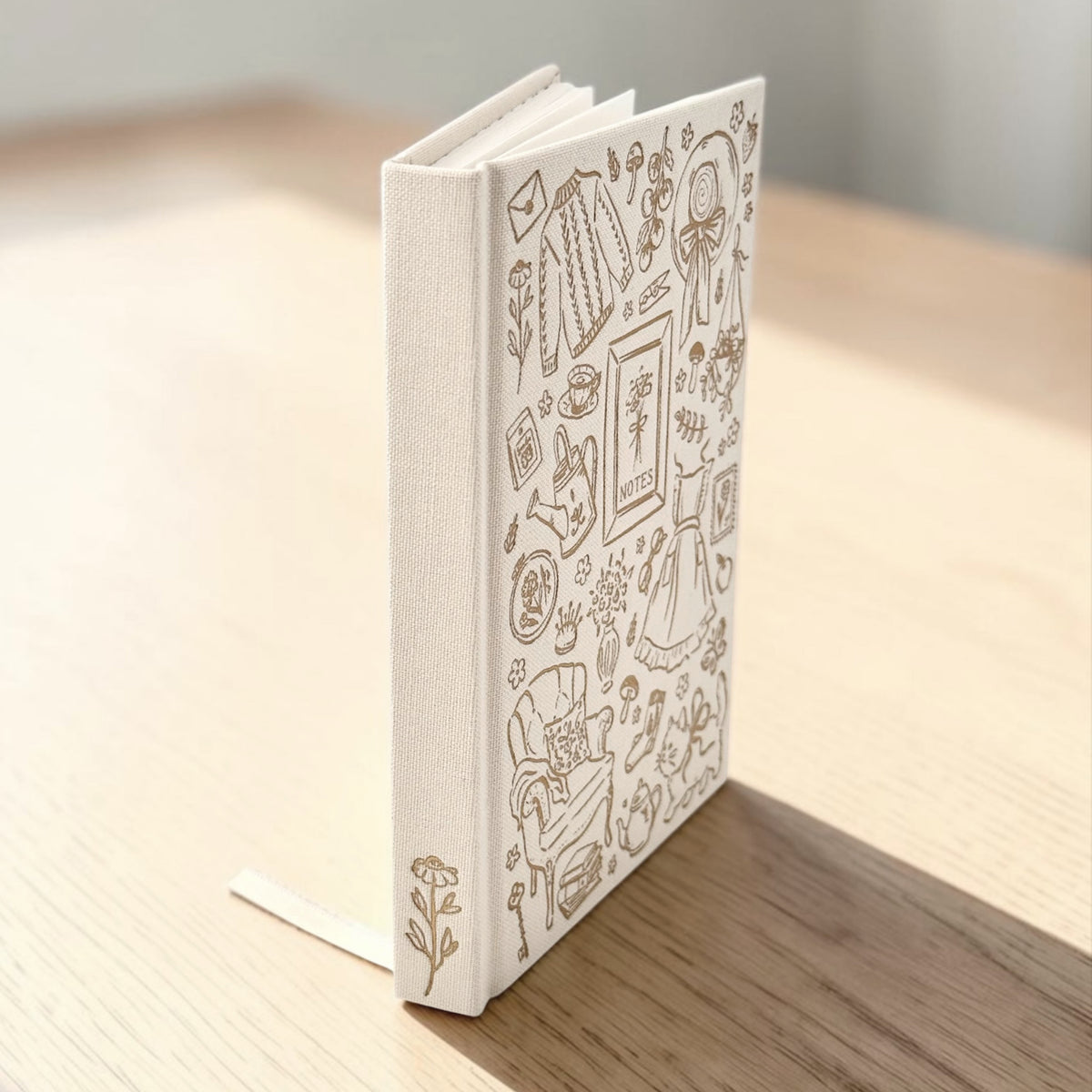Picture of linen journal spine with flower detail on wood background