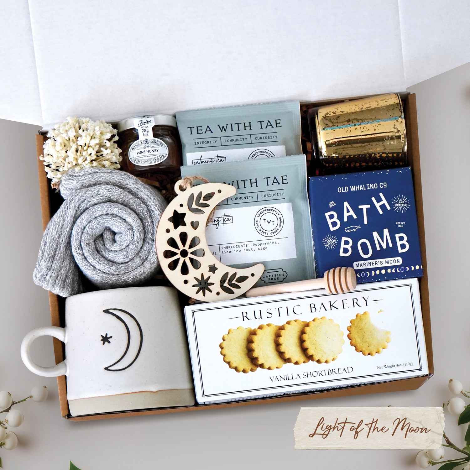 Light of the Moon mug box comes with moon and sun ceramic mug, cozy boot socks, mini honey and dipper, 2 tea bags, moon wood nordic ornament, old whaling co mariners moon bath bomb, votive and tea light 