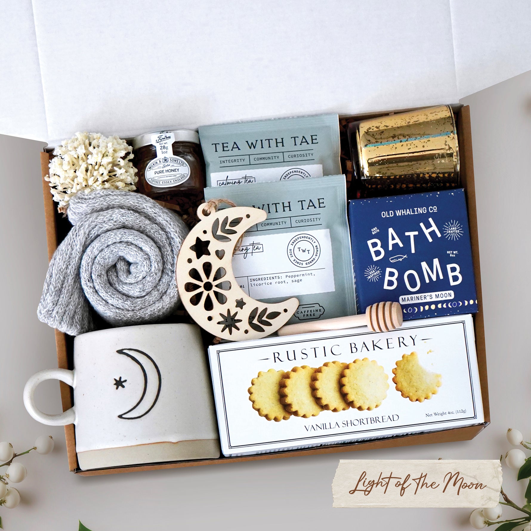 Light of the Moon mug box comes with moon and sun ceramic mug, cozy boot socks, mini honey and dipper, 2 tea bags, moon wood nordic ornament, old whaling co mariners moon bath bomb, votive and tea light 