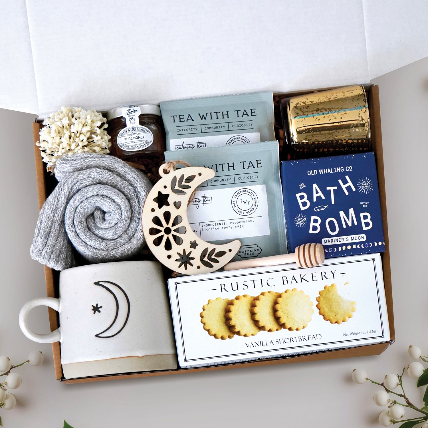 Light of the Moon mug box comes with moon and sun ceramic mug, cozy boot socks, mini honey and dipper, 2 tea bags, moon wood nordic ornament, old whaling co mariners moon bath bomb, votive and tea light 