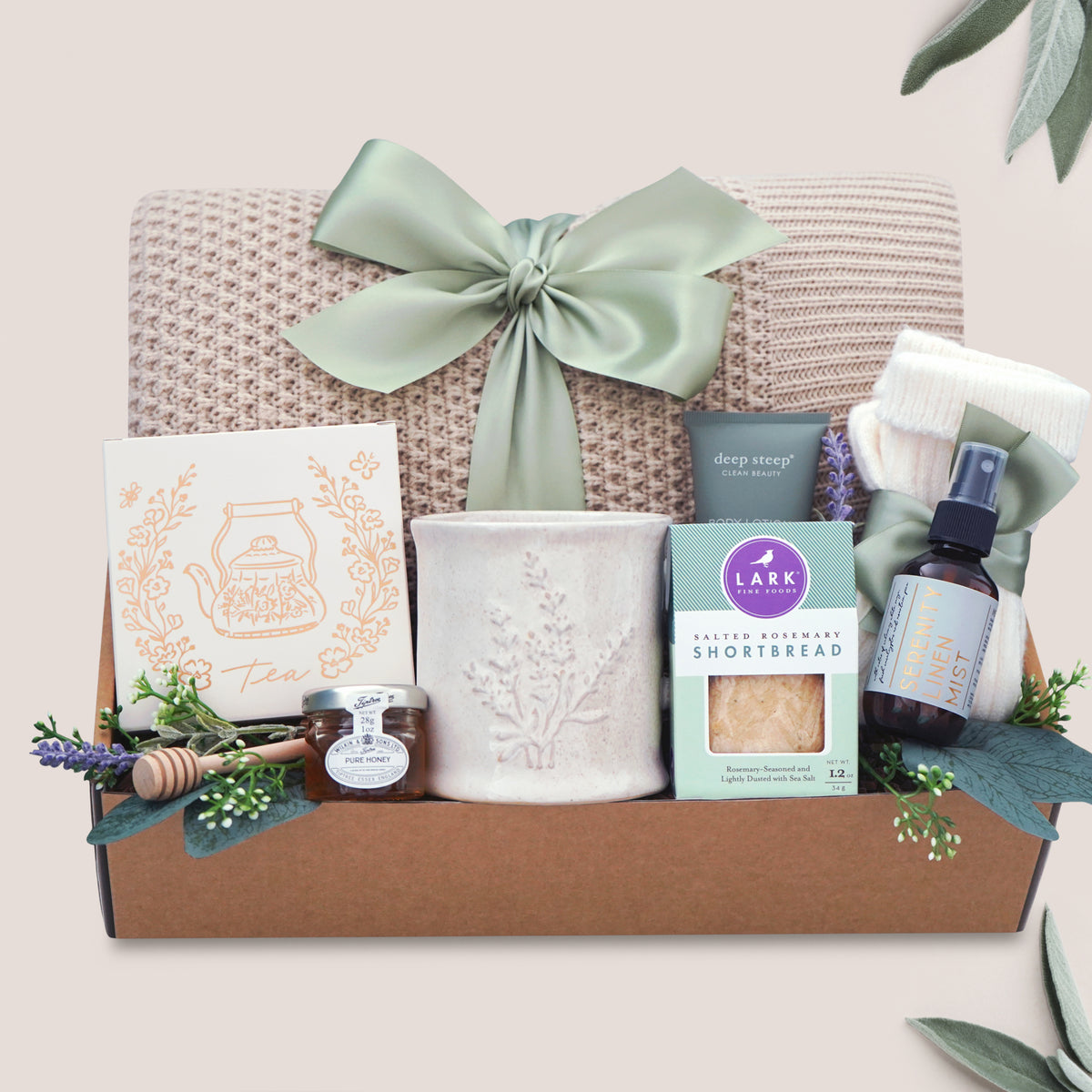 Calming Moments Wildflower Pop knit blanket, mug, tea, cookies, spa items on a tan background 