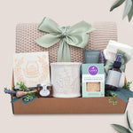 Calming Moments Wildflower Pop knit blanket, mug, tea, cookies, spa items on a tan background 