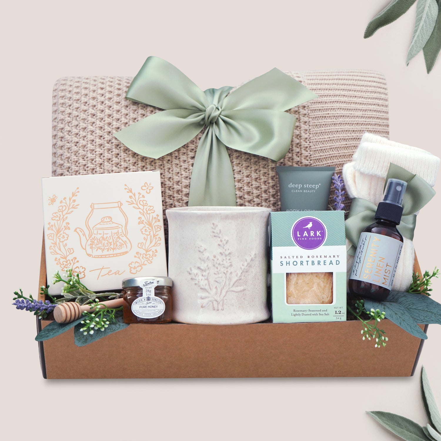 Calming Moments Wildflower Pop knit blanket, mug, tea, cookies, spa items on a tan background 