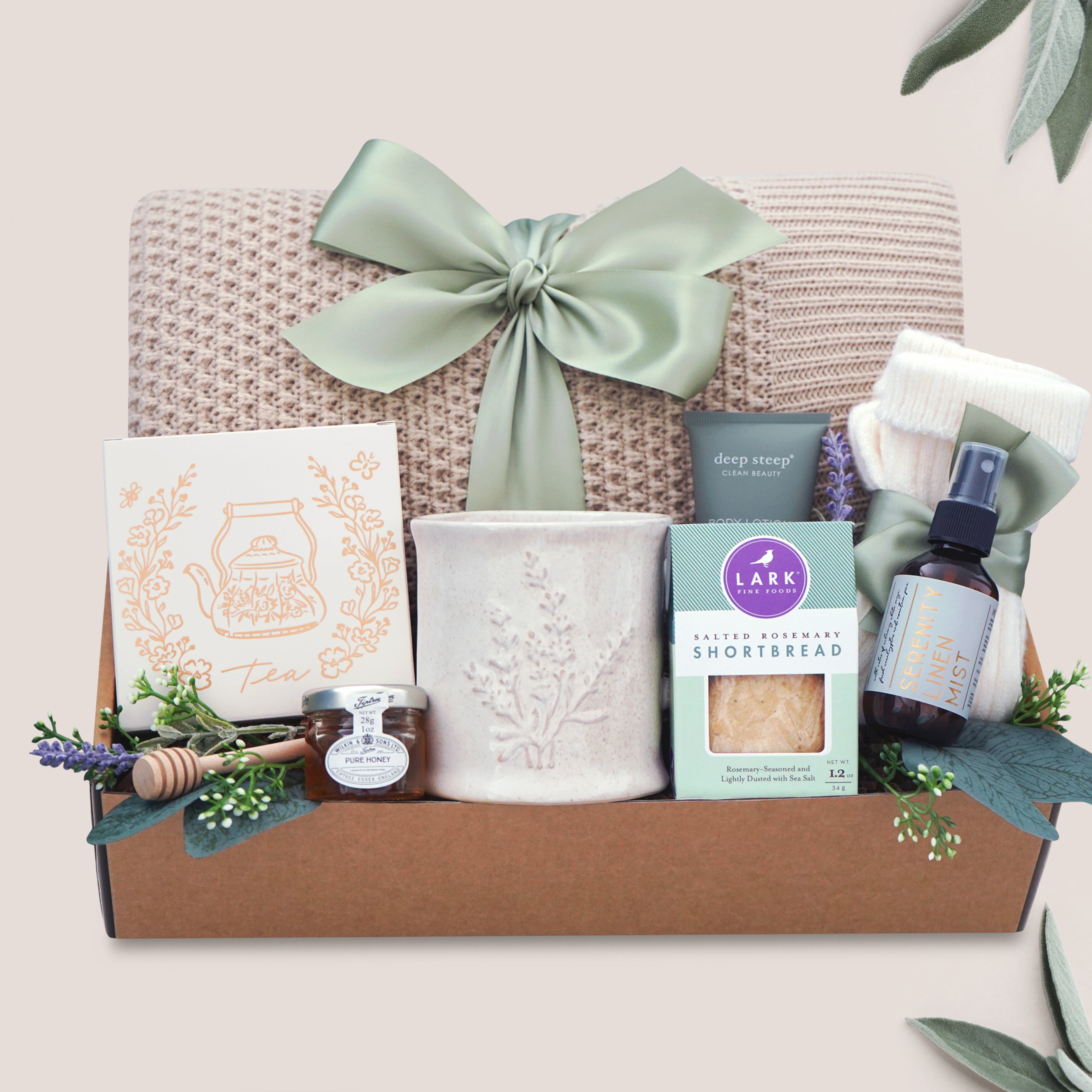 Calming Moments Wildflower Pop knit blanket, mug, tea, cookies, spa items on a tan background 