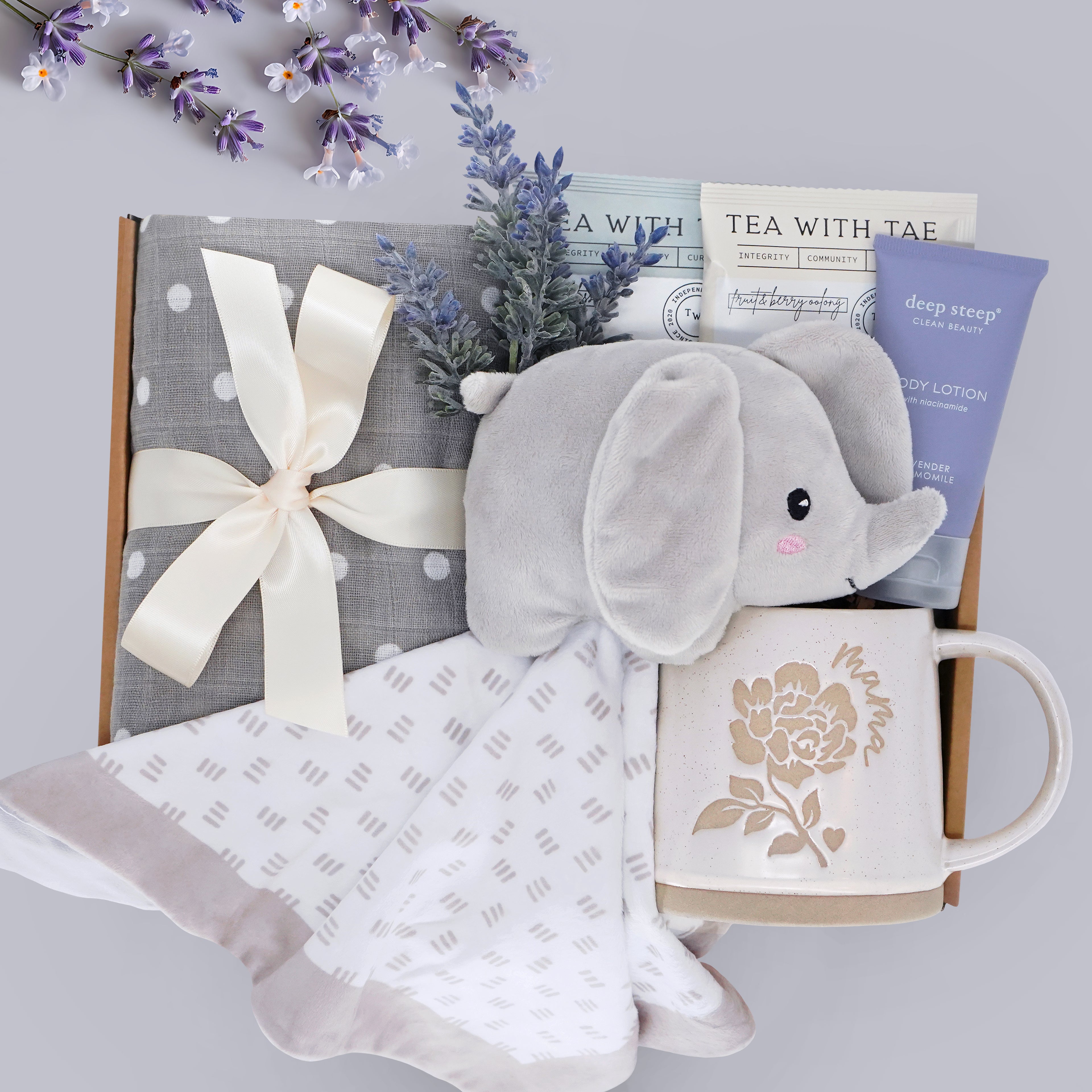 Wildflower Pop Hello Cutie New Mama box comes with grey and white polka dot swaddle, Elephant Snuggie blanket, 2 tea bags, lavender body lotion, and choice of mug
