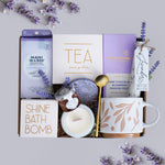 Wildflower Pop Gift set with tea, chocolate, candle, and bath bomb on a light gray background with lavender flowers.