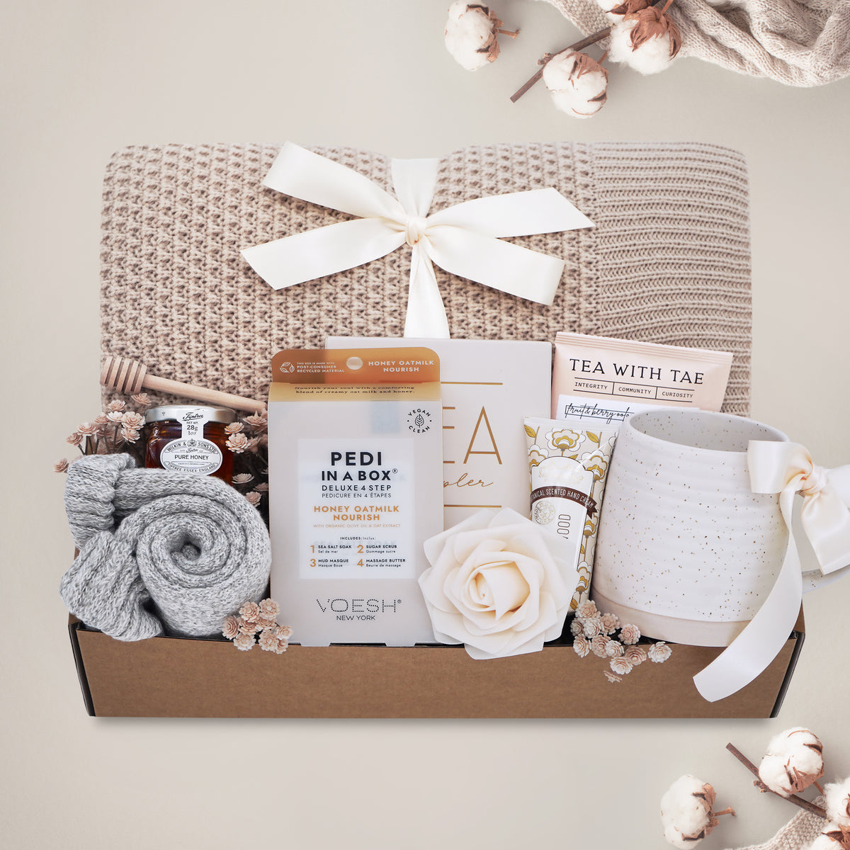 Oatmeal and Honey gift box with honeycomb blanket, tea sampler, pedi kit, grey cozy boot socks, mini honey and dipper, hand cream, and Wildflower Pop exclusive Farmhouse mug