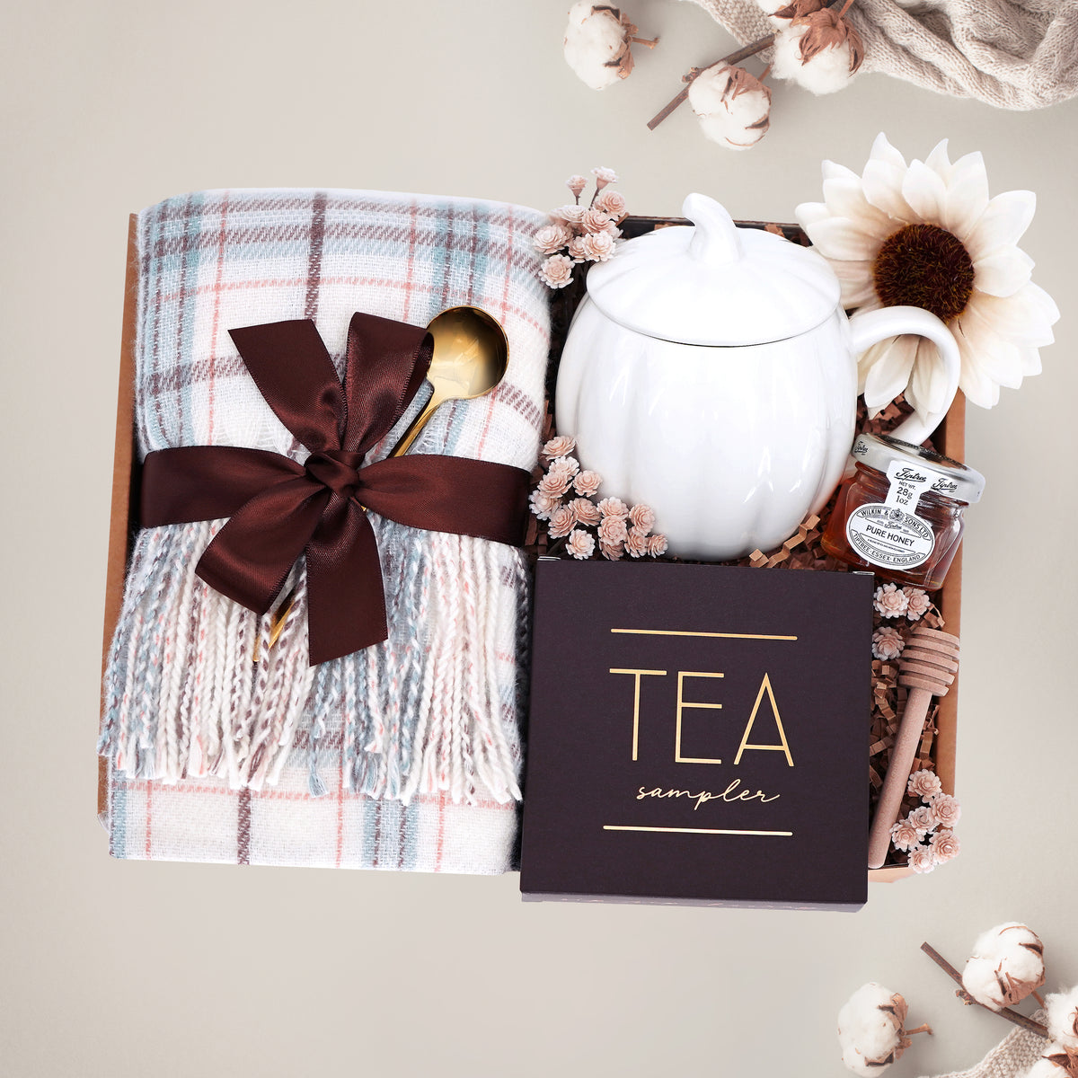Scarf Weather gift set with cozy plaid scarf, pumpkin mug, tea sampler, and mini honey and dipper on a gray background