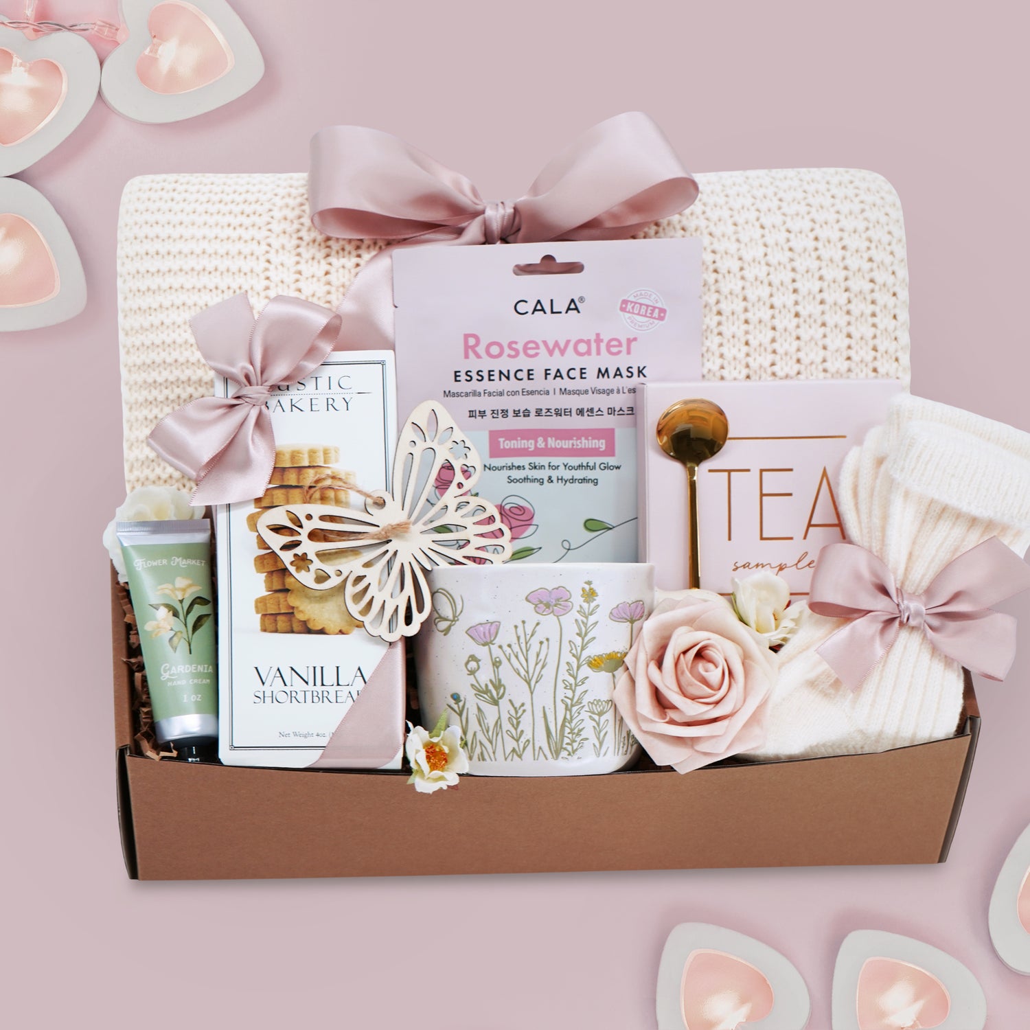 Wildflower Pop wildflower meadow blanket gift box with a cream lace knit blanket, Rosewater face mask, gold spoon, tea sampler, cream knit socks, faux rose, wildflower ceramic mug, wood butterfly ornament, Rustic bakery vanilla shortbread, Flower Market gardenia hand lotion 