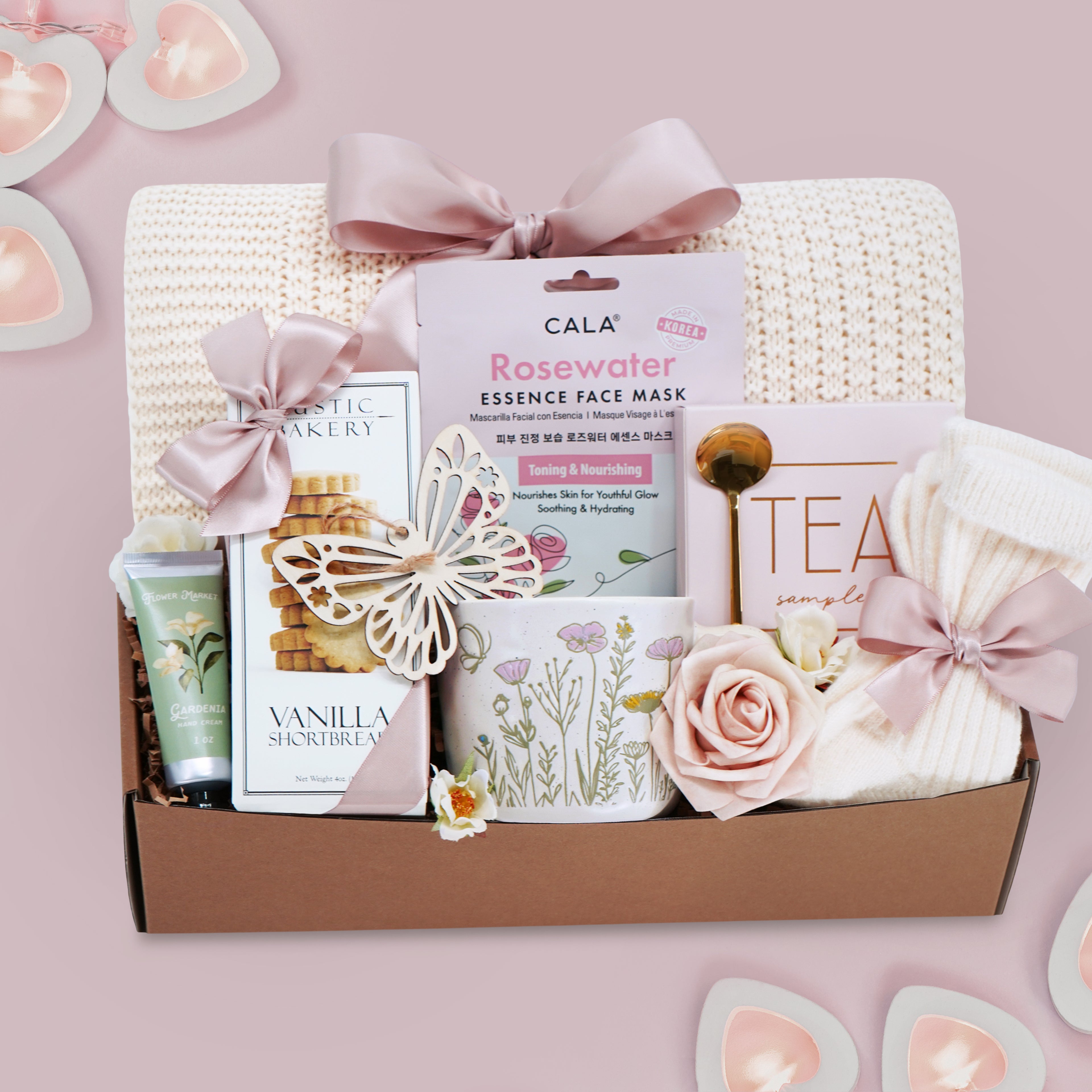 Wildflower Pop wildflower meadow blanket gift box with a cream lace knit blanket, Rosewater face mask, gold spoon, tea sampler, cream knit socks, faux rose, wildflower ceramic mug, wood butterfly ornament, Rustic bakery vanilla shortbread, Flower Market gardenia hand lotion 
