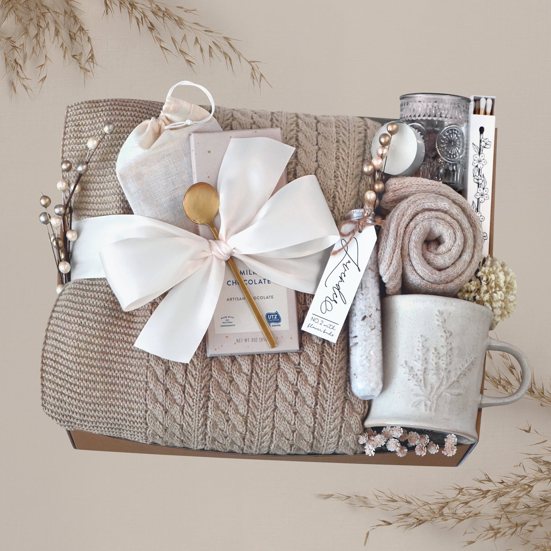 Wildflower Pop Cozy Cable Blanket Gift Box with tan cable knit blanket, Moonstruck Milk Chocolate, Floral bath salts, Lavender Sprig Mug, Cozy Boot socks, Tea, votive and Tea Light