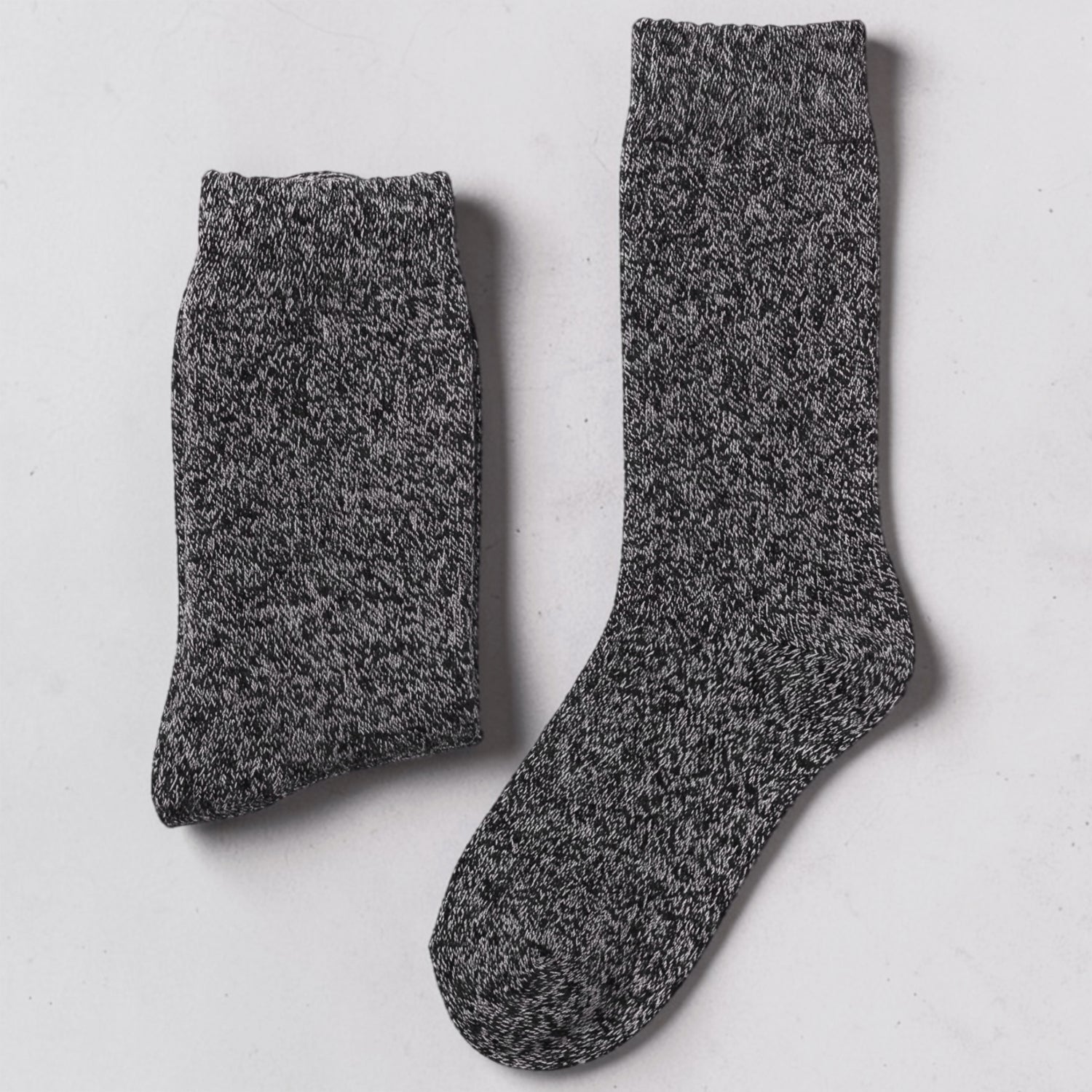 A pair of dark gray mens heathered knit crew socks laid flat on a light gray surface.