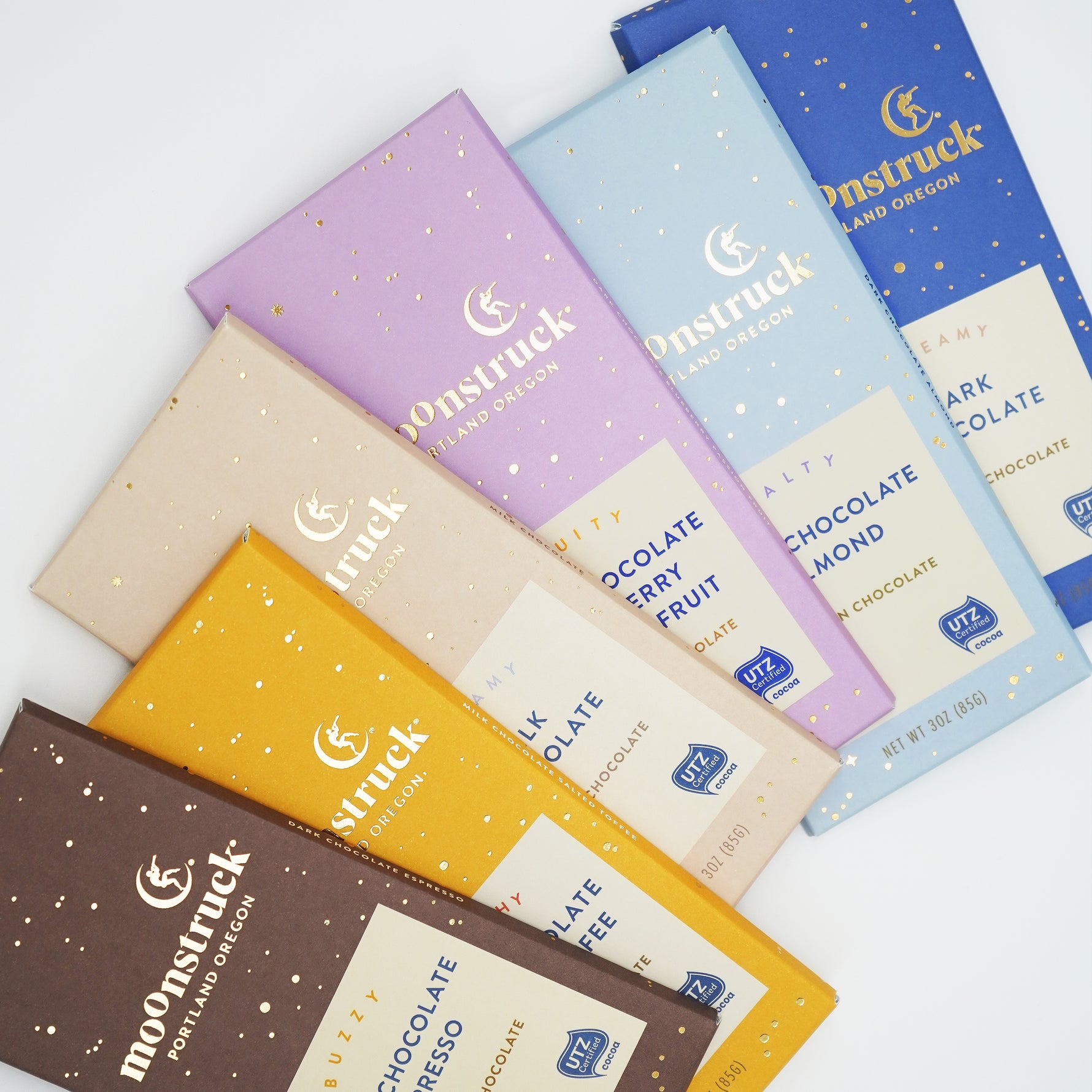 Assorted moonstruck chocolate bars in various flavors on a white background
