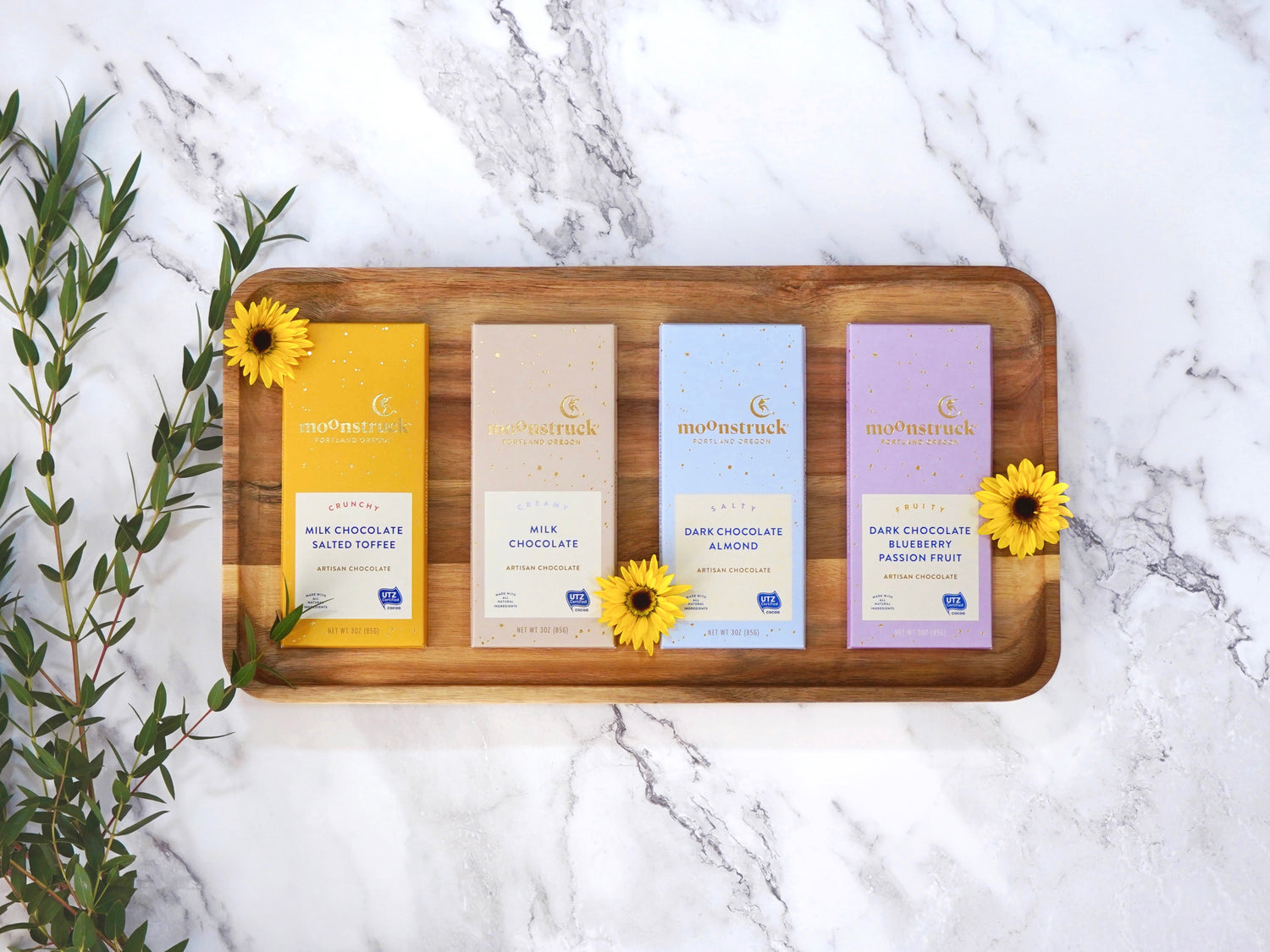 Moonstruck Chocolate bar in a variety of flavors each bar is 3oz, shown is milk chocolate salted toffee, milk chocolate, dark chocolate almond, and dark chocolate blueberry and passionfruit 