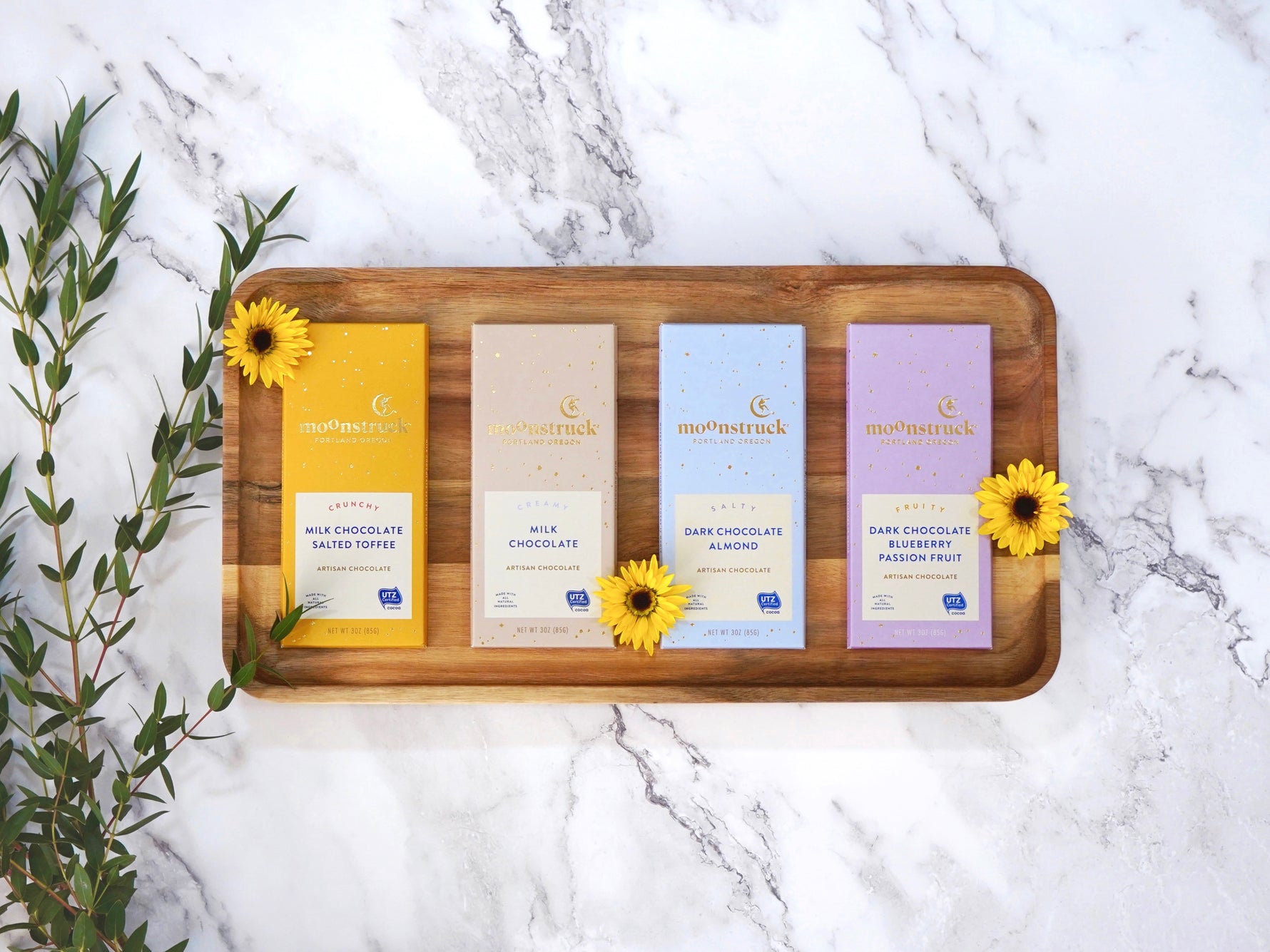 Moonstruck Chocolate bar in a variety of flavors each bar is 3oz, shown is milk chocolate salted toffee, milk chocolate, dark chocolate almond, and dark chocolate blueberry and passionfruit 