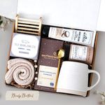 The Nicely Neutral Mug Gift Box comes with a ceramic beehive mug, old whaling co bamboo and teak bar of soap, cozy boot socks, bamboo soap rack, moonstruck espresso dark chocolate bar, gold spoon, tea tube with 5 tea bags, and coconut and honey hand cream 3.3 oz
