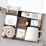 The Nicely Neutral Mug Gift Box comes with a ceramic beehive mug, old whaling co bamboo and teak bar of soap, cozy boot socks, bamboo soap rack, moonstruck espresso dark chocolate bar, gold spoon, tea tube with 5 tea bags, and coconut and honey hand cream 3.3 oz
