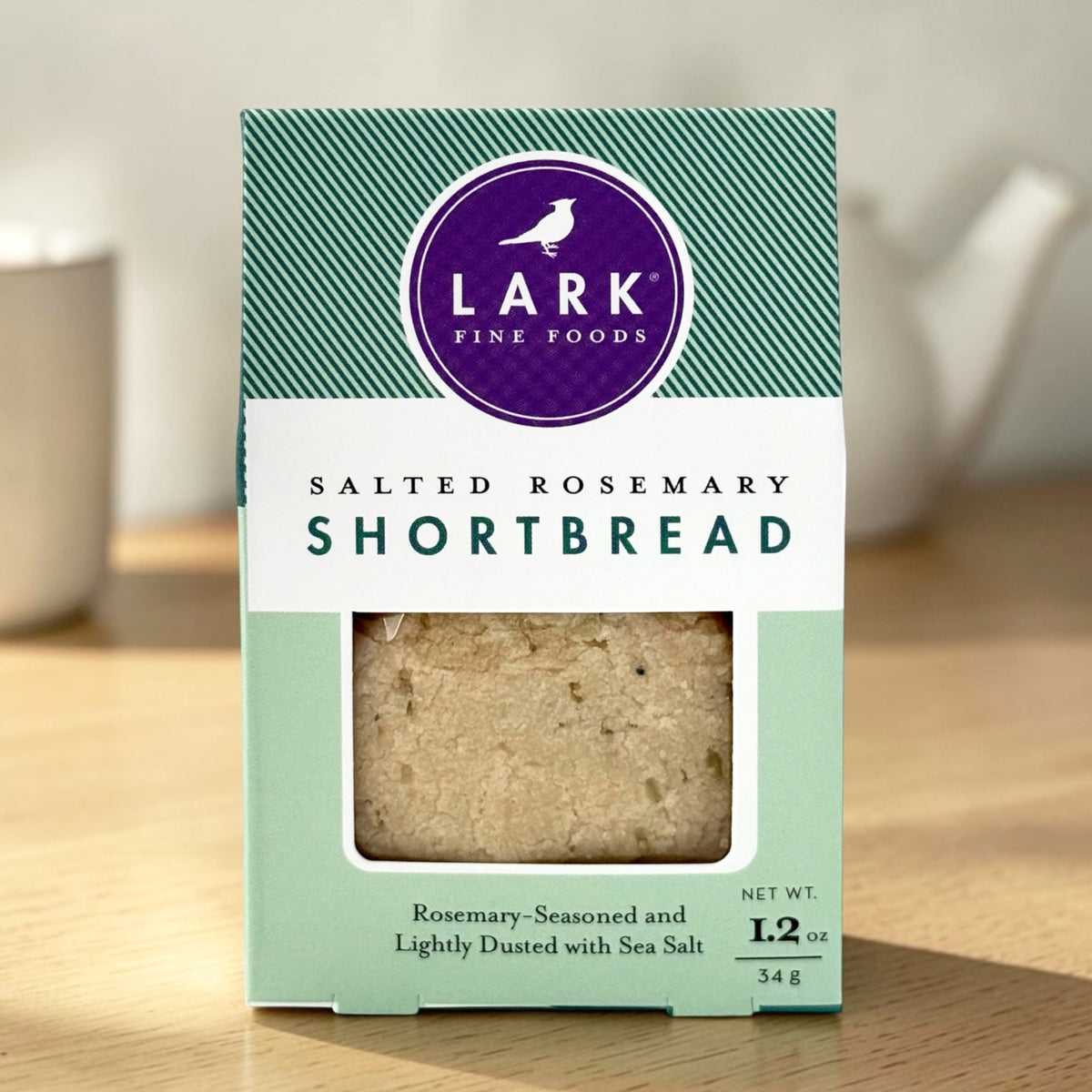 A package of Lark Fine Foods Salted Rosemary Shortbread on a wooden surface.