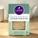 A package of Lark Fine Foods Salted Rosemary Shortbread on a wooden surface.