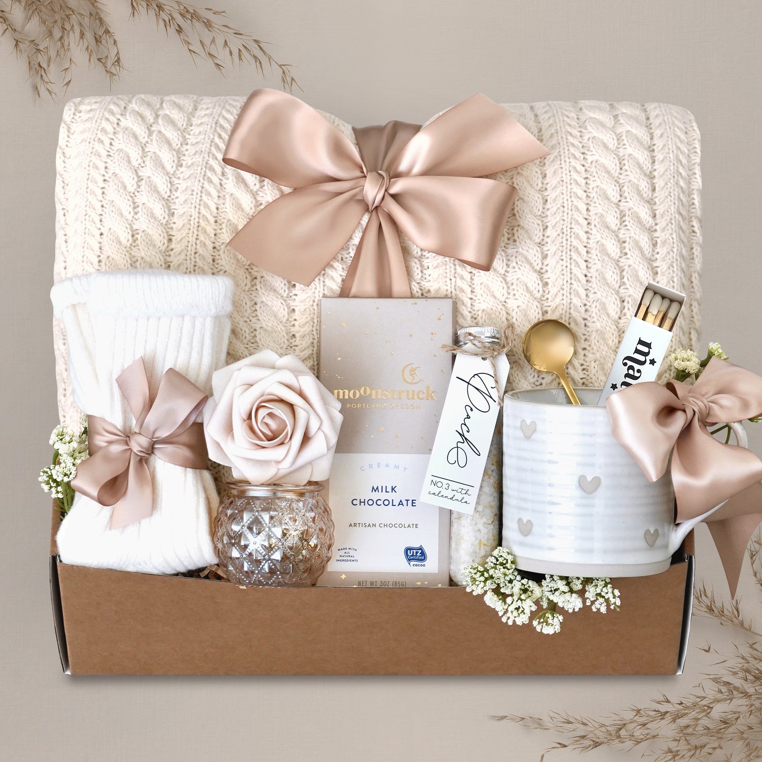 Wildflower Pop Sending Serenity Blanket Gift Box with cream cable knit blanket, moonstruck chocolate, cream knit socks, floral bath salts, Wildflower Pop ceramic heart mug, matches, votive and tea light 
