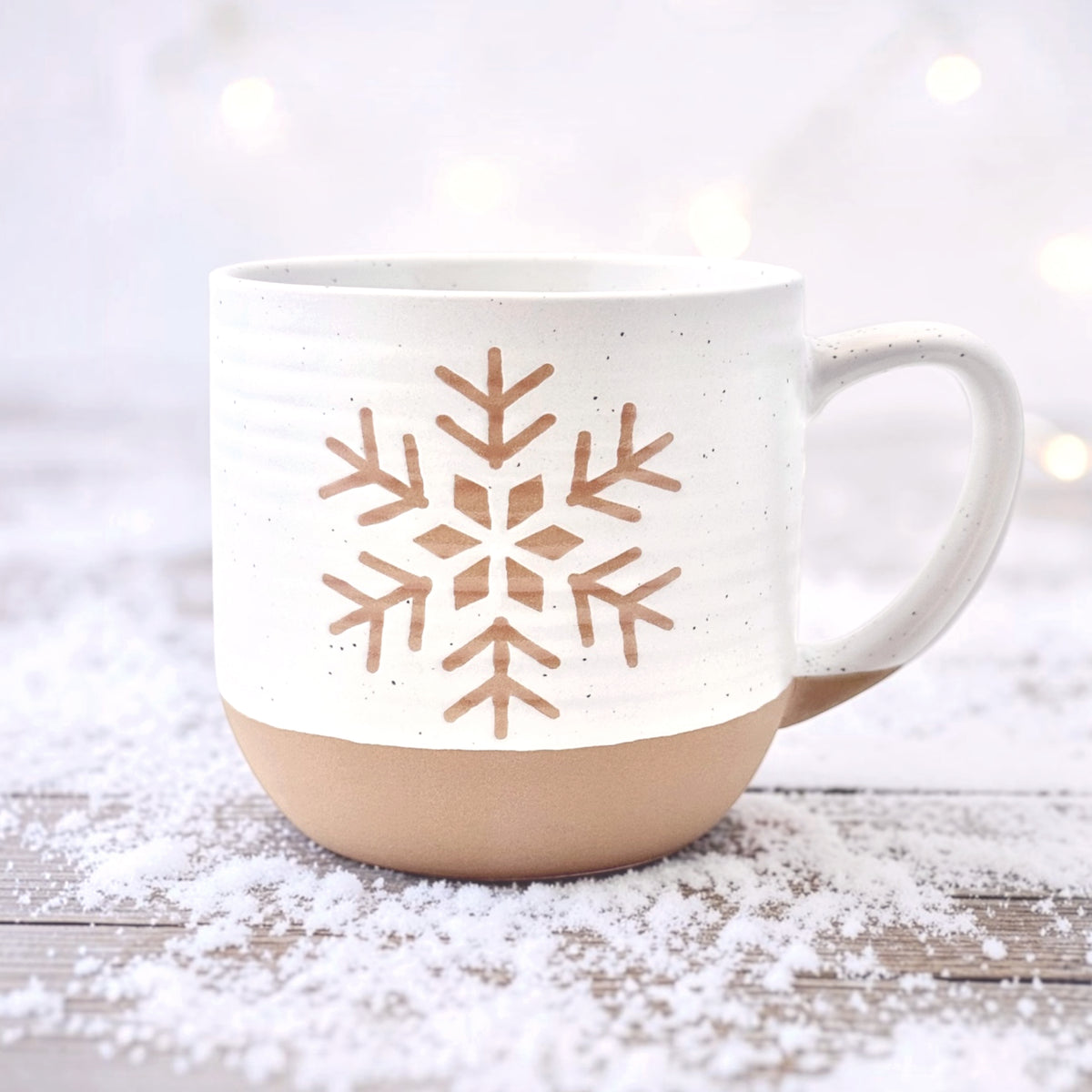 Rustic ceramic snowflake mug with white speckle glaze on winter background
