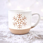 Rustic ceramic snowflake mug with white speckle glaze on winter background