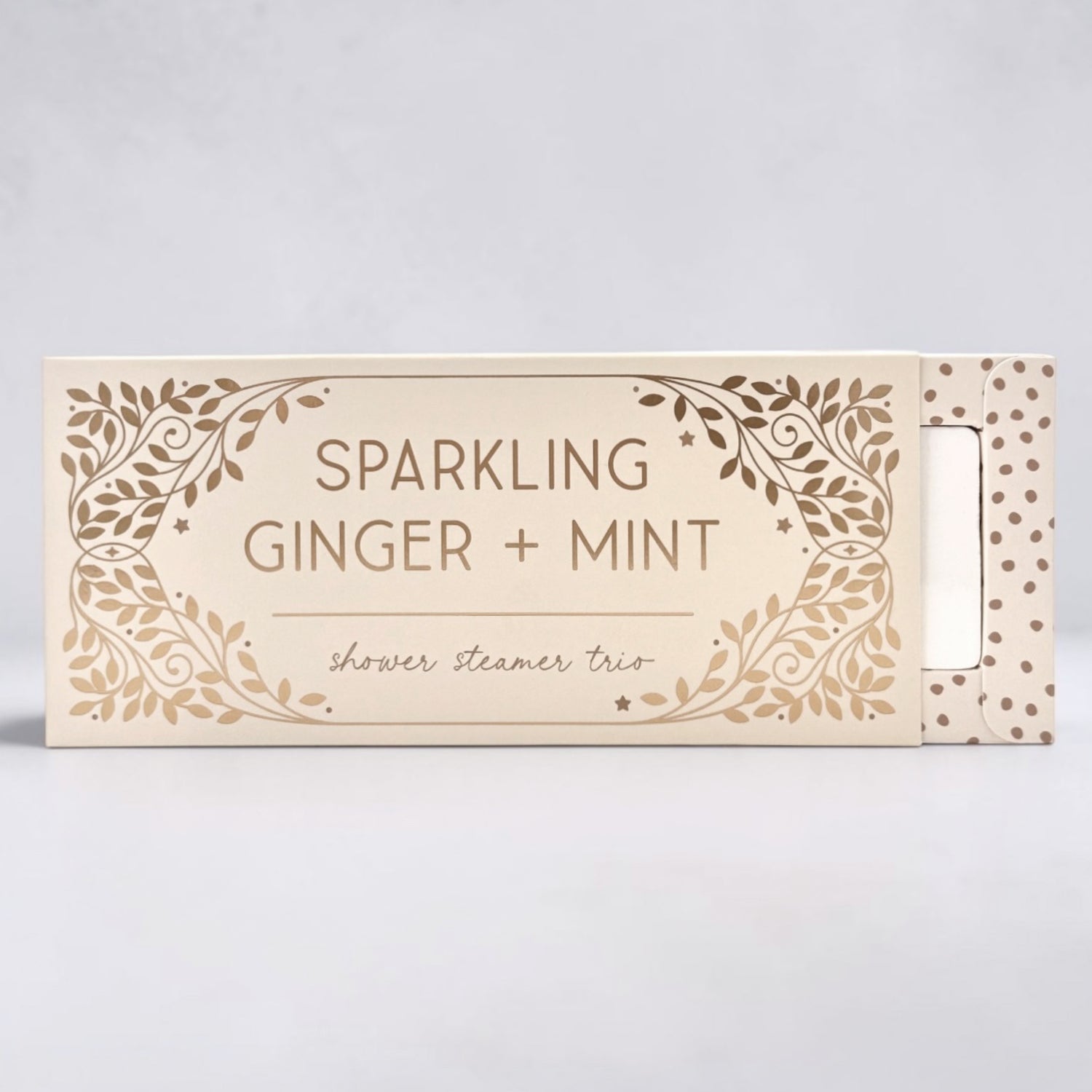 Box of sparkling ginger and mint shower steamer trio on a light gray background