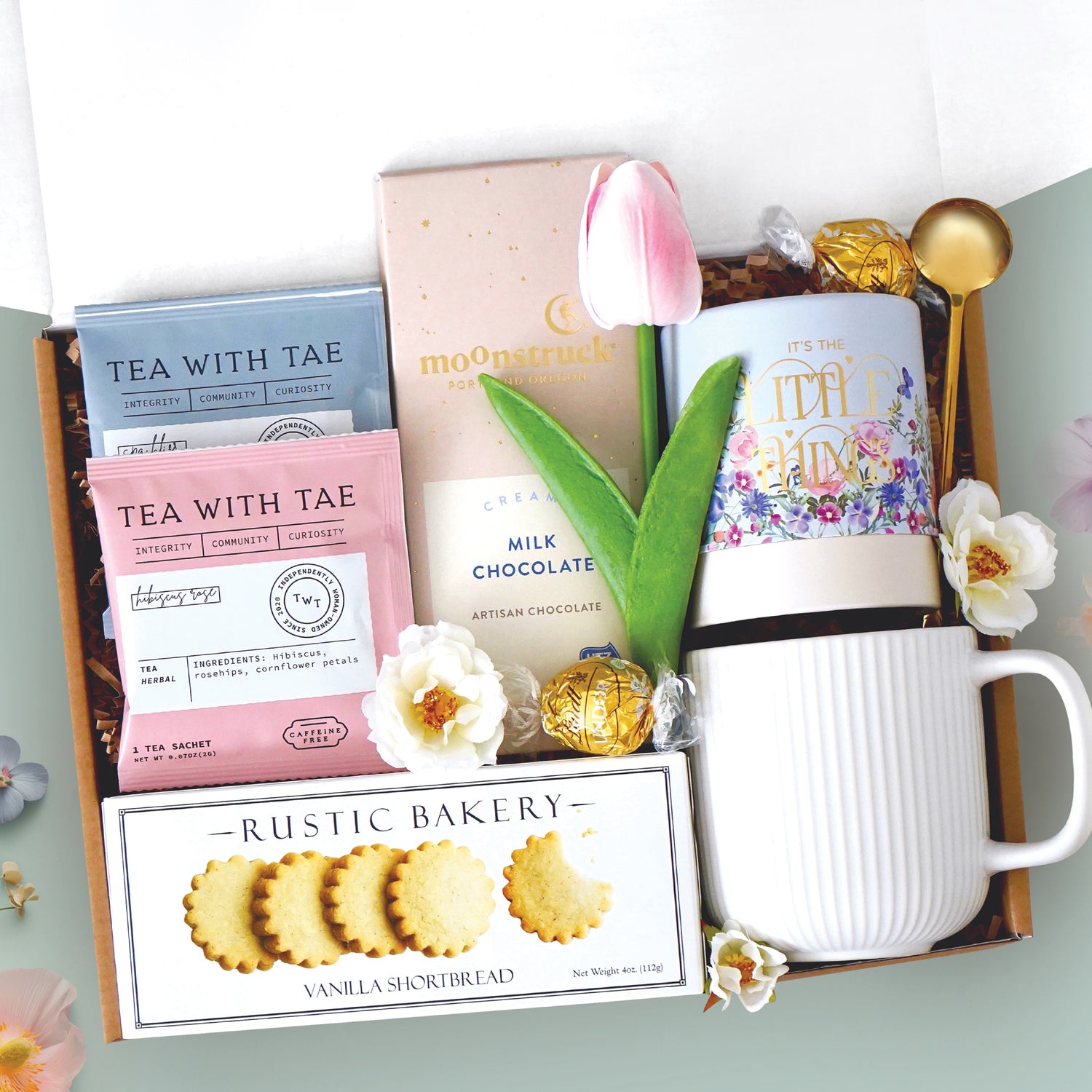 Spring sweet treats mug box come with a ribbed white ceramic mug, it's the little things tube with lindt truffles, gold demitasse spoon, full size milk chocolate moonstruck bar, 2 tea with tae tea bags, and rustic bakery vanilla shortbread cookies 
