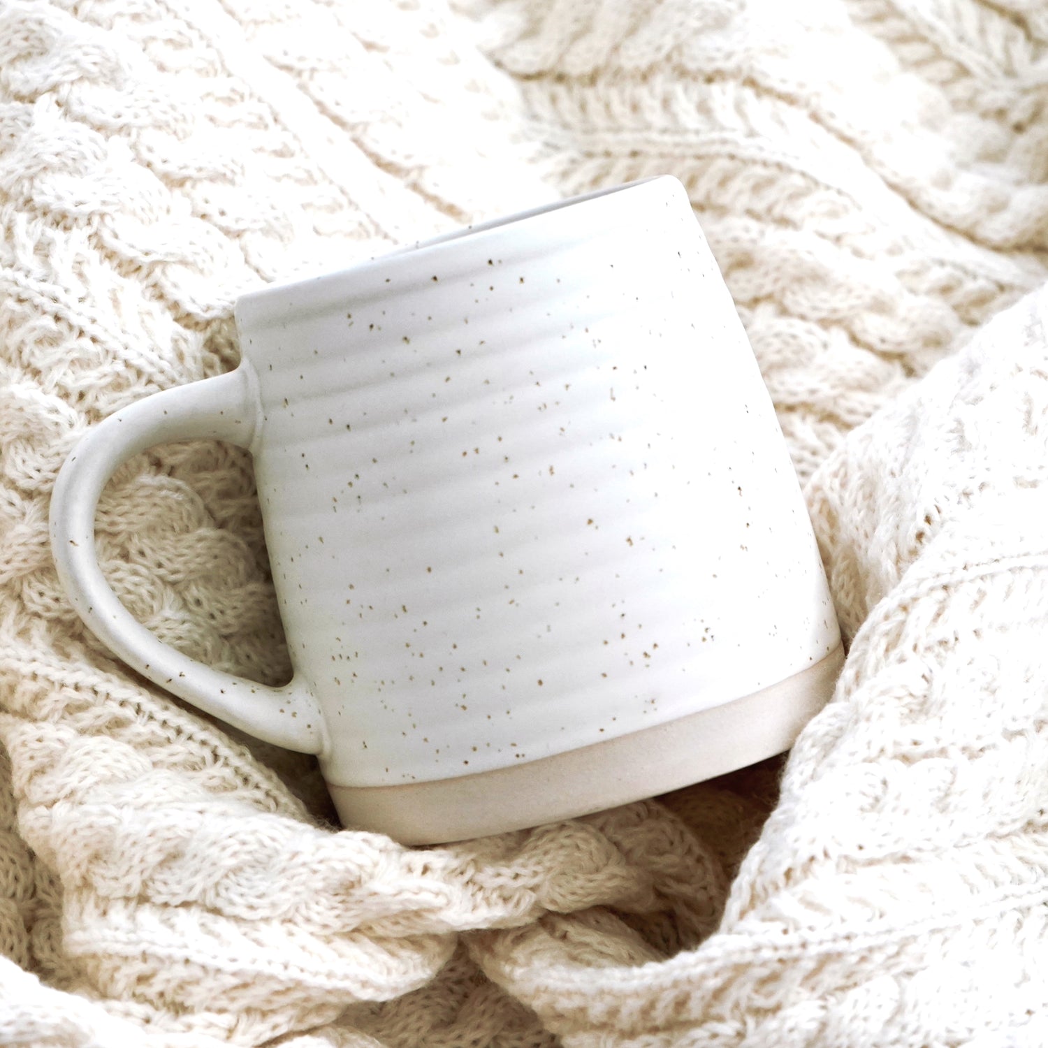 Rustic farmhouse ceramic mug on a textured beige blanket