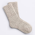 A pair of oatmeal tan cozy boot socks shown on a clean, light gray background.