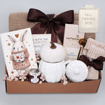 Gift basket with a blanket, drink sampler, and decorative items on a light gray background