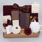 Gift basket with chocolate, tea set, and other items on a light gray background