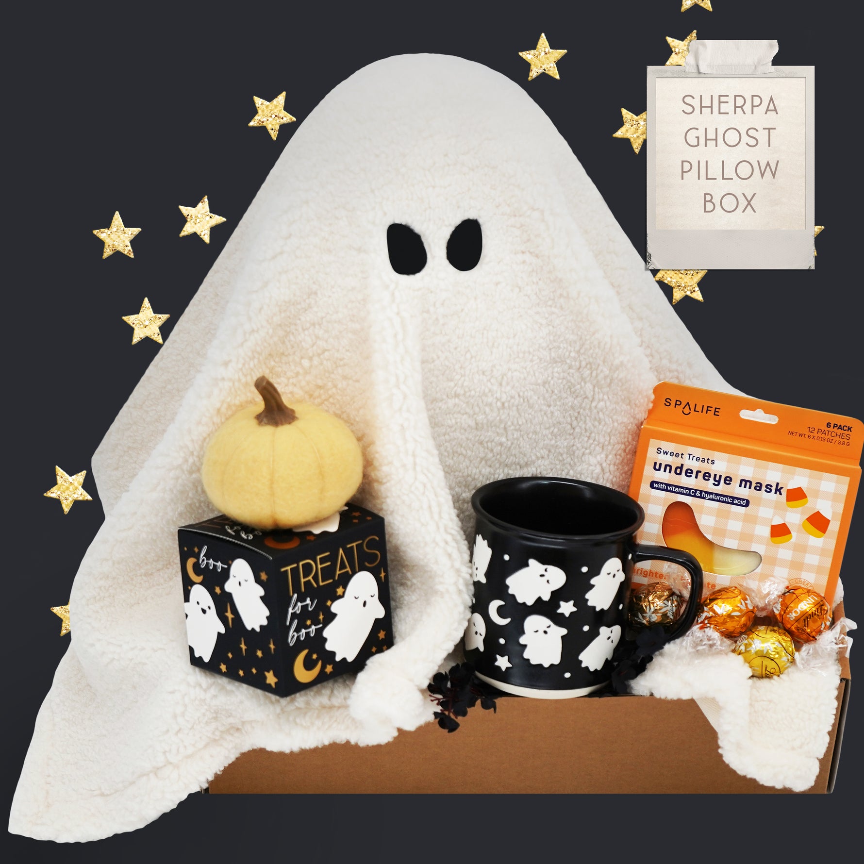 Halloween-themed gift set with ghost pillow, pumpkin, Wildflower Pop Ghost mug, and candy on a dark background.
