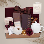 Rustic Retreat blanket gift basket with chocolate, tea set, and other items on a light gray background