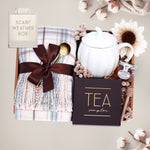 Scarf Weather gift set with cozy plaid scarf, pumpkin mug, tea sampler, and mini honey and dipper on a gray background