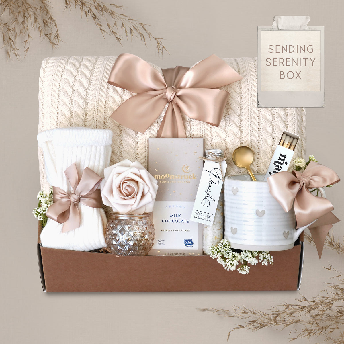 Wildflower Pop Sending Serenity Blanket Gift Box with cream cable knit blanket, moonstruck chocolate, cream knit socks, floral bath salts, Wildflower Pop ceramic heart mug, matches, votive and tea light 