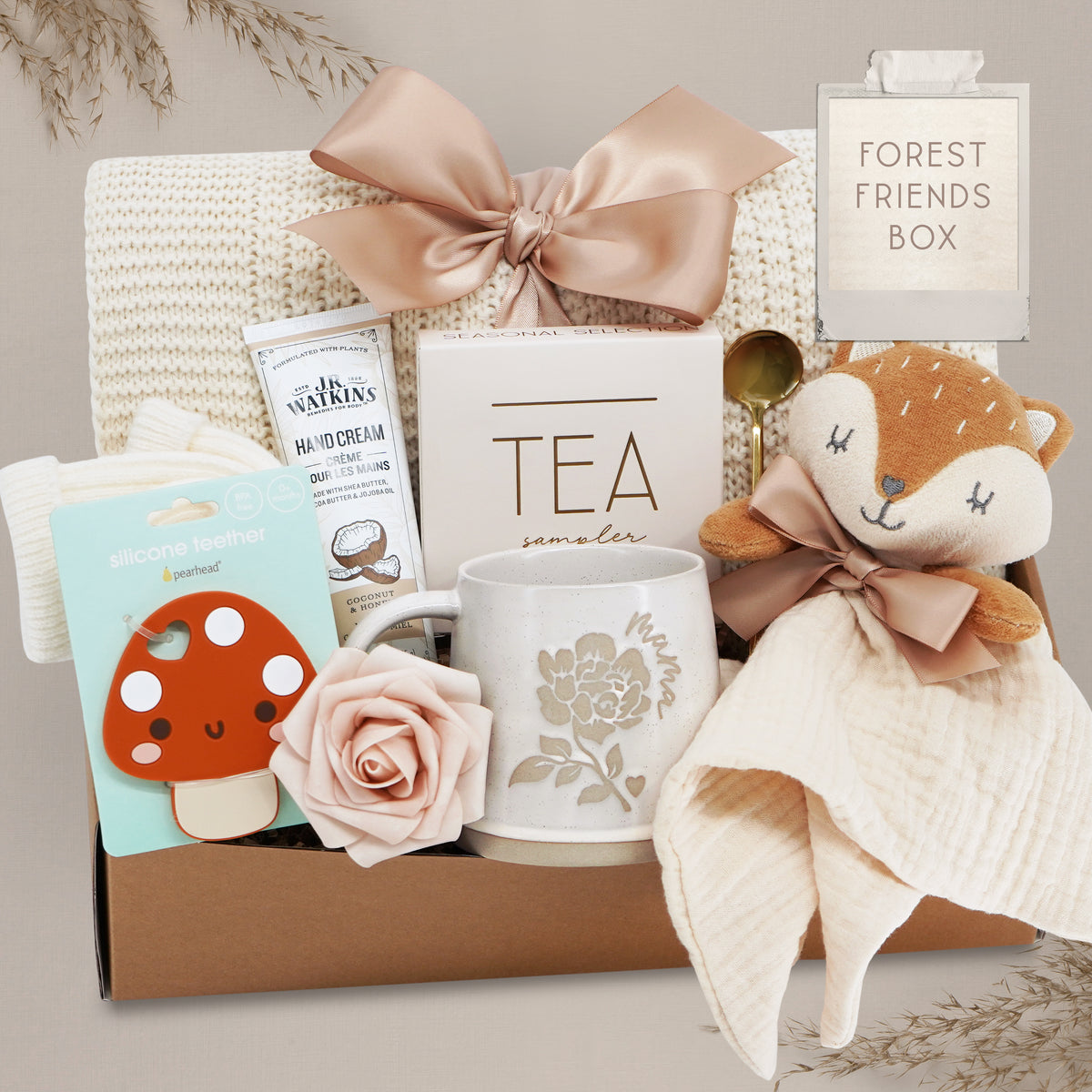 Wildflower Pop Forest Friends New Baby and New Mama Blanket Gift Box comes with a cream lace knit blanket tied with a nude bow, JR Watkins lotion, Pearhead Mushroom silicone teether, faux rose, Wildflower Pop ceramic mama mug, Tea Sampler, Fox movie and gold demiatsse spoon