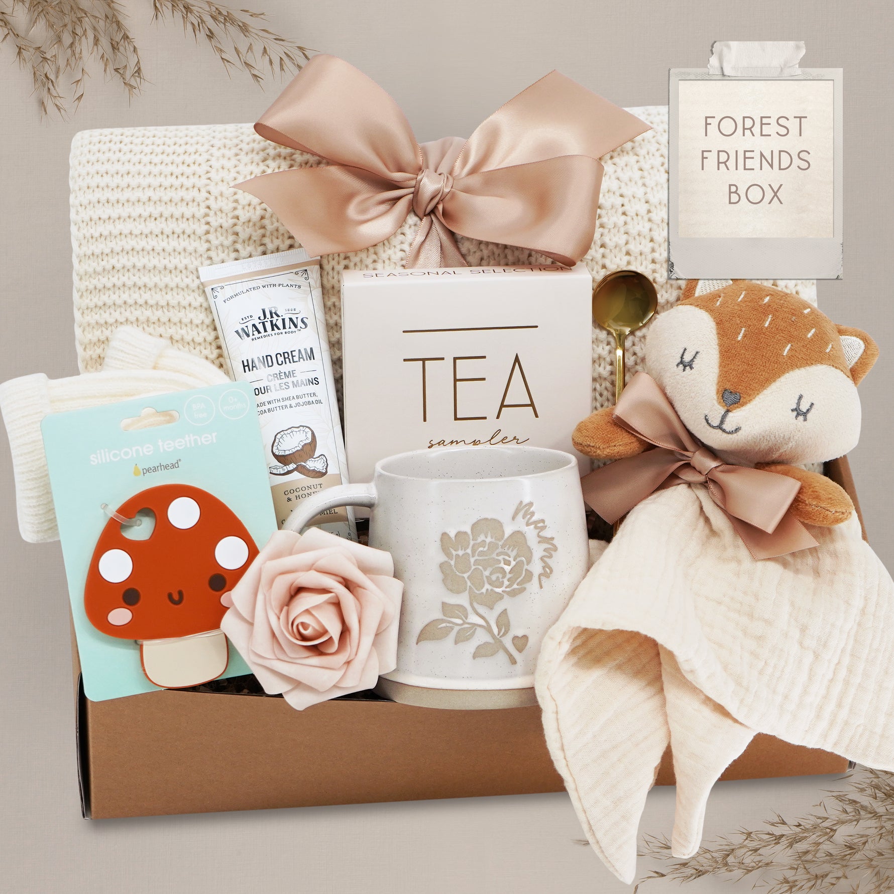 Wildflower Pop Forest Friends New Baby and New Mama Blanket Gift Box comes with a cream lace knit blanket tied with a nude bow, JR Watkins lotion, Pearhead Mushroom silicone teether, faux rose, Wildflower Pop ceramic mama mug, Tea Sampler, Fox movie and gold demiatsse spoon