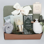 Wildflower Pop Silver Forest Blanket gift box, with sage green lace knit blanket, cream ribbed ceramic mug, grey cozy boot socks, silver votive and tea light, mini honey and dipper, silver birch and cedar shower steamers, and tea sampler
