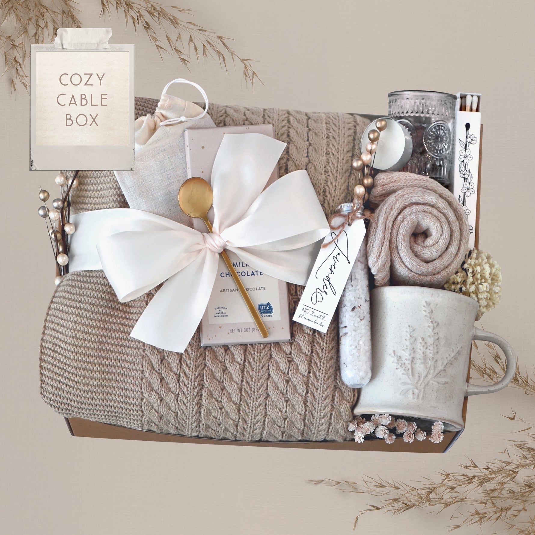 Wildflower Pop Cozy Cable Blanket Gift Box with tan cable knit blanket, Moonstruck Milk Chocolate, Floral bath salts, Lavender Sprig Mug, Cozy Boot socks, Tea, votive and Tea Light